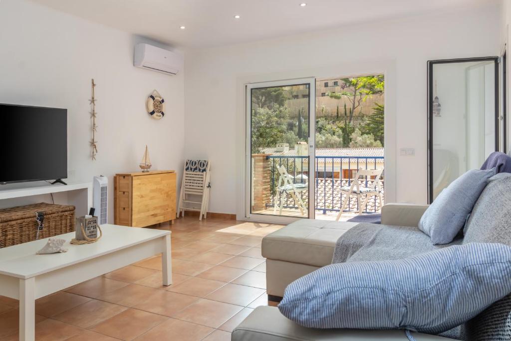 a living room with a couch and a tv at La caseta de Sa Riera in Begur