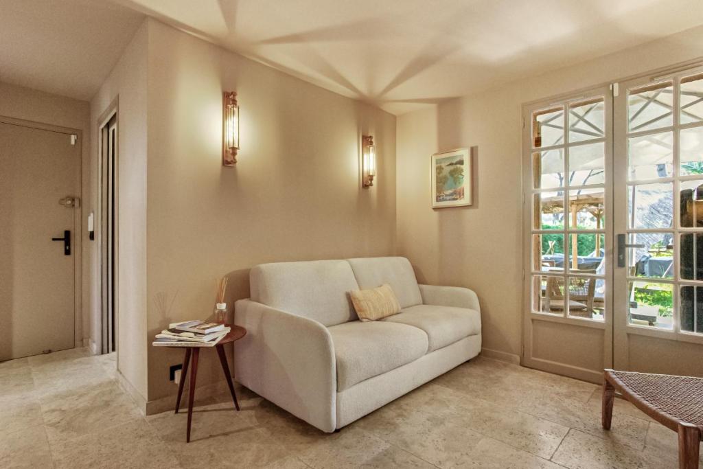 a living room with a chair and a table at Le Cocon Blanc - T3 - Gassin in Gassin