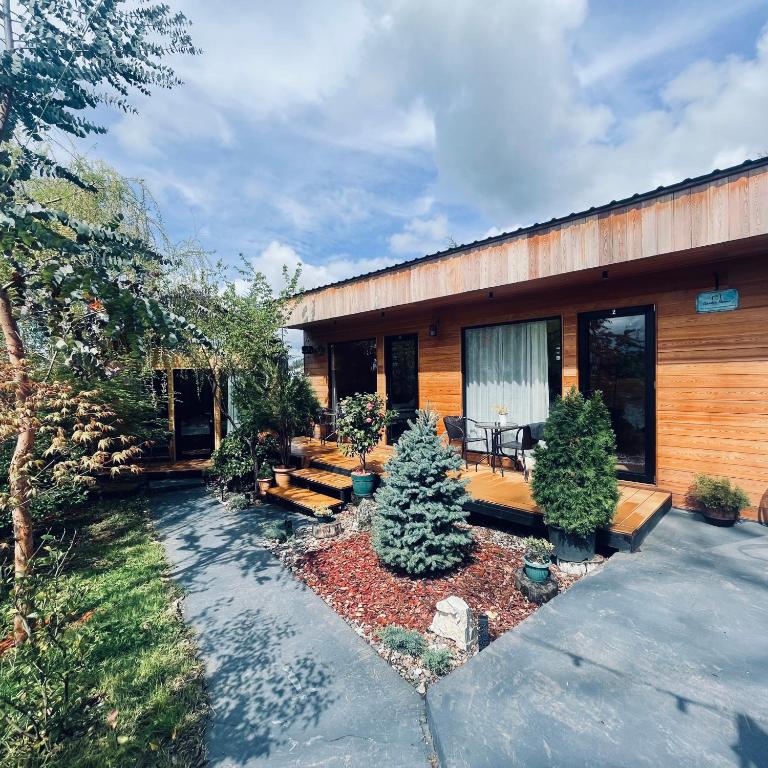 a house with a patio with trees in the yard at Garden rooms in Kutaisi in Kutaisi