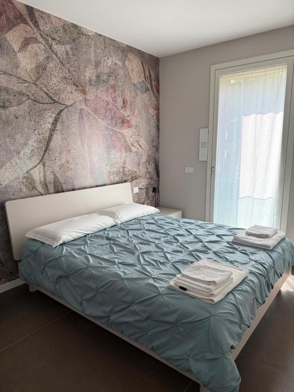 a bedroom with a bed with a painting on the wall at Residenza San Rocco in Pedemonte