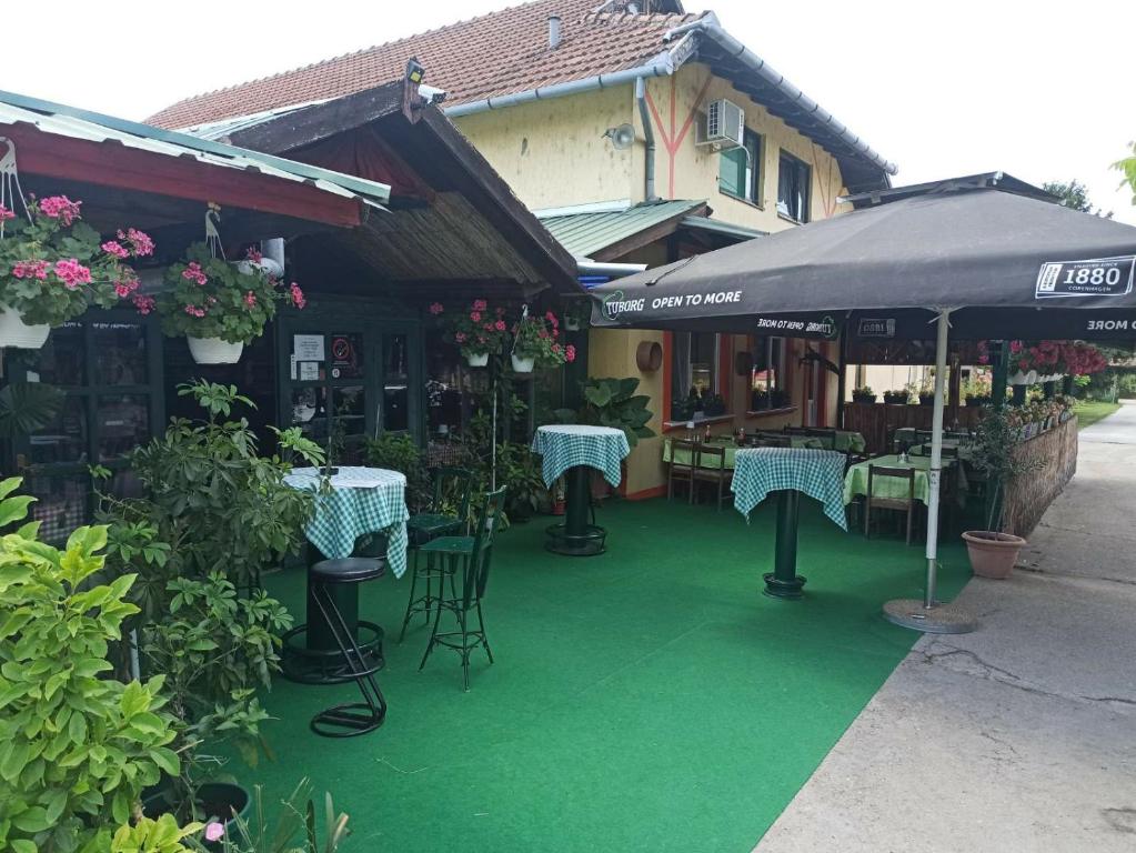 a patio with tables and chairs and an umbrella at Guljaš Čarda Old in Šupljak