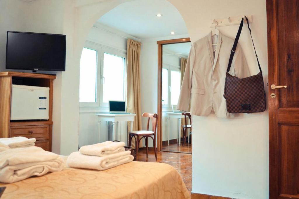 a hotel room with a bed with a coat on a wall at Ortegal Urban Suites in Mar del Plata