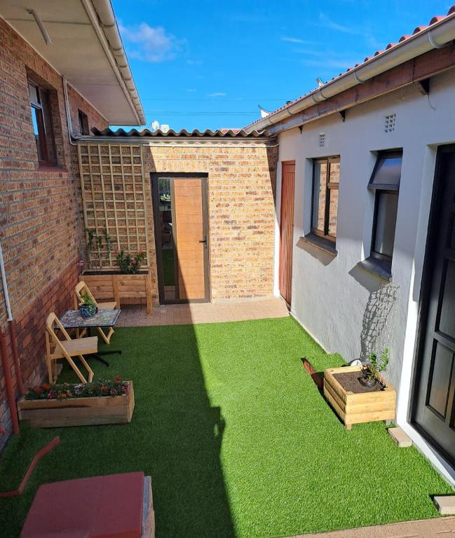a small yard with green grass in a house at 77 on First! in Fish Hoek