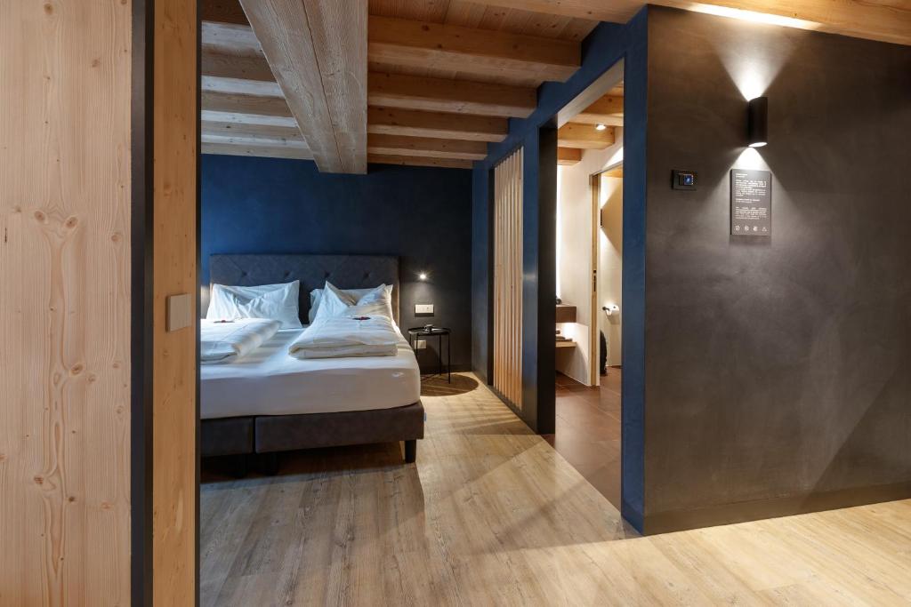 a bedroom with a bed and a blue wall at Wind Villa Genf Spa - Relax in Livigno