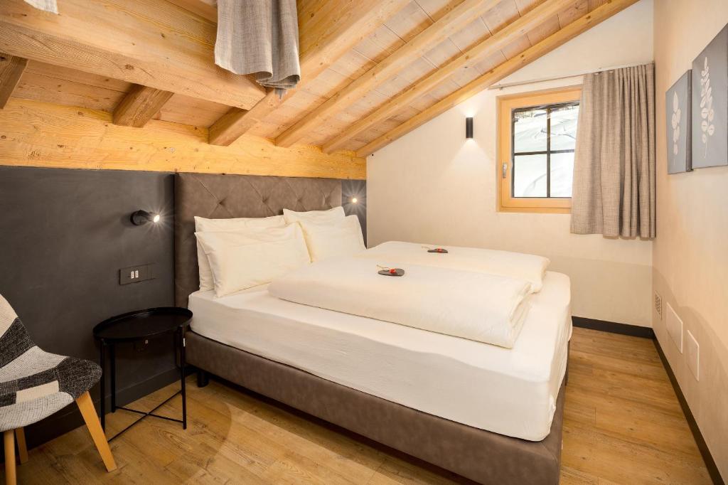 a bedroom with a large white bed in a room at Chalet River Villa Genf Spa - Relax in Livigno