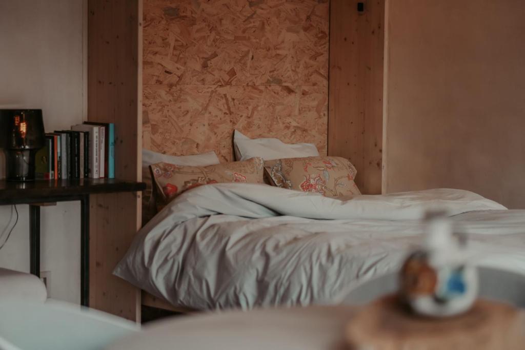 a bedroom with a bed and a wall with books at Huis De Mijmering in Heikant
