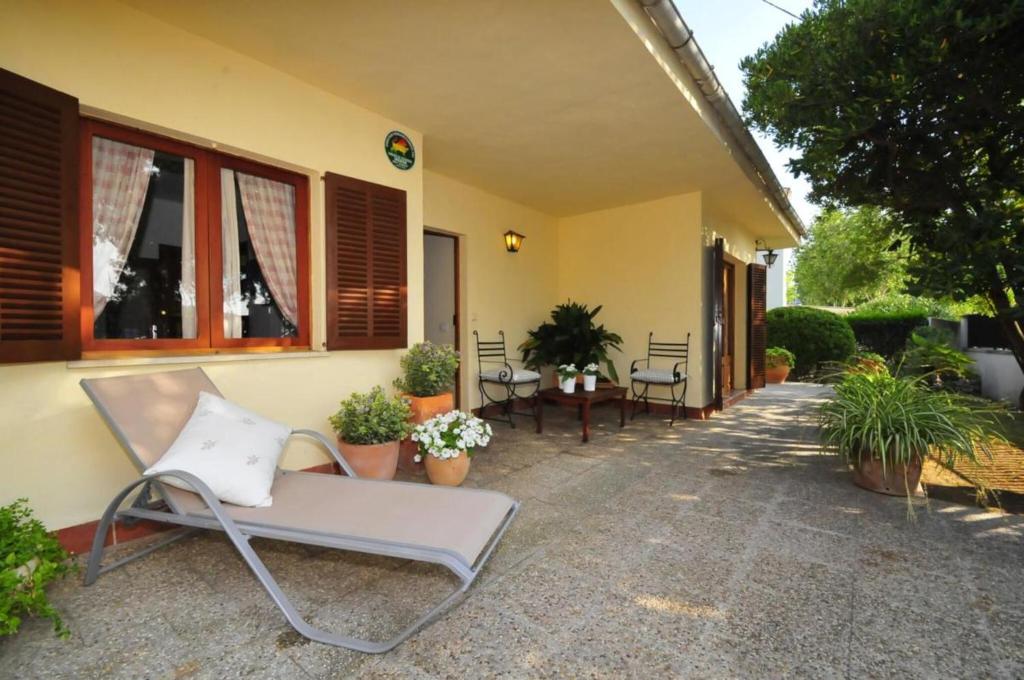 a chair sitting outside of a house with plants at Cora in Alcudia