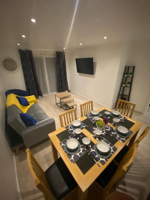a dining room with a table and a couch at Charming Contractors & Family Friendly 3-BR House in Harlow, Essex in Great Parndon