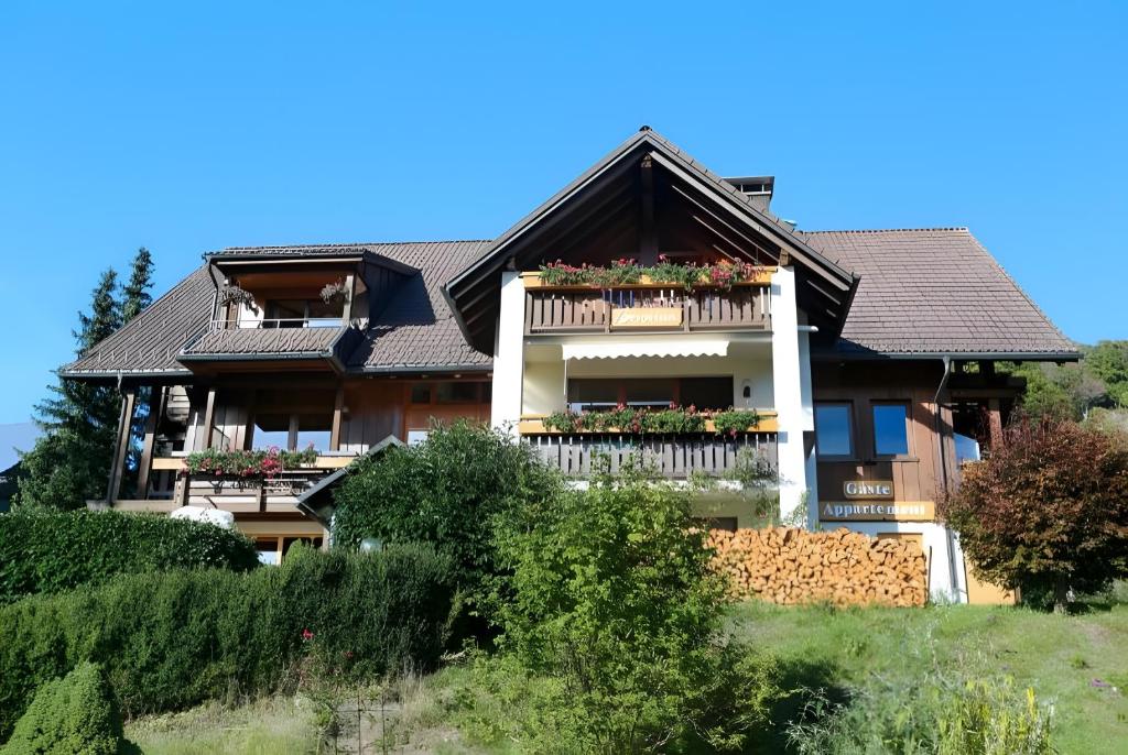 a house on a hill with flowers on the balcony at Appartment Bergblick in Bernau im Schwarzwald