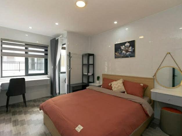 a bedroom with a bed and a desk and a mirror at Sky Home in Da Lat