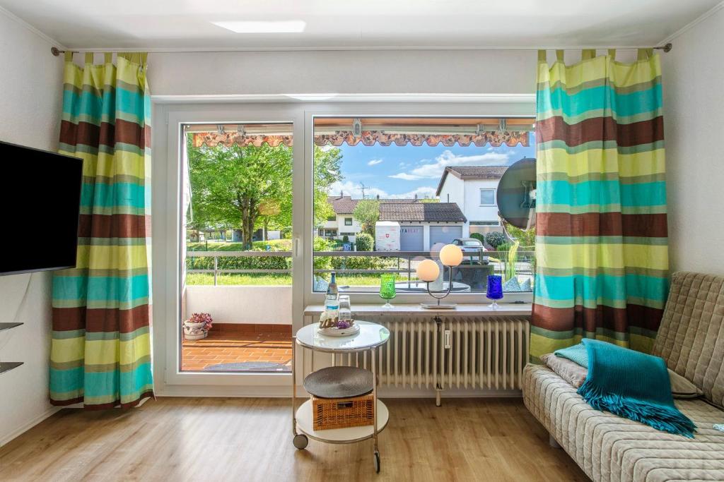 a living room with a couch and a large window at Ferienappartement Magjar in Küssaberg