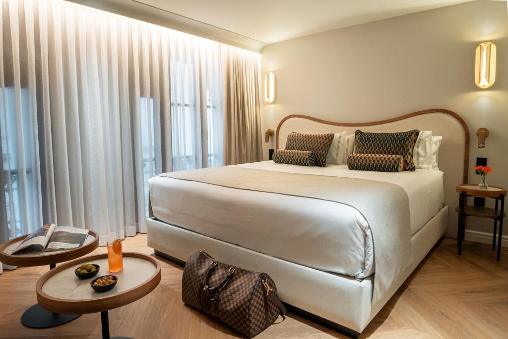 a bedroom with a white bed and a large window at Hotel Condal in Barcelona