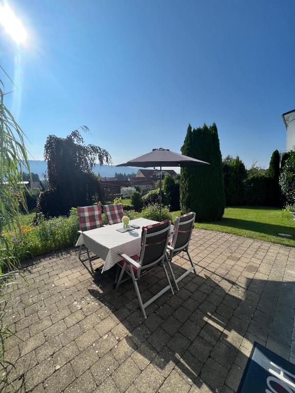 a table and chairs with an umbrella on a patio at Sonnenhang in Sigmarszell