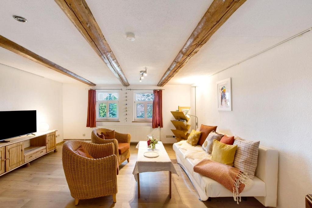 a living room with a couch and chairs and a tv at Ferienwohnung Gartenfreude in Veckenstedt