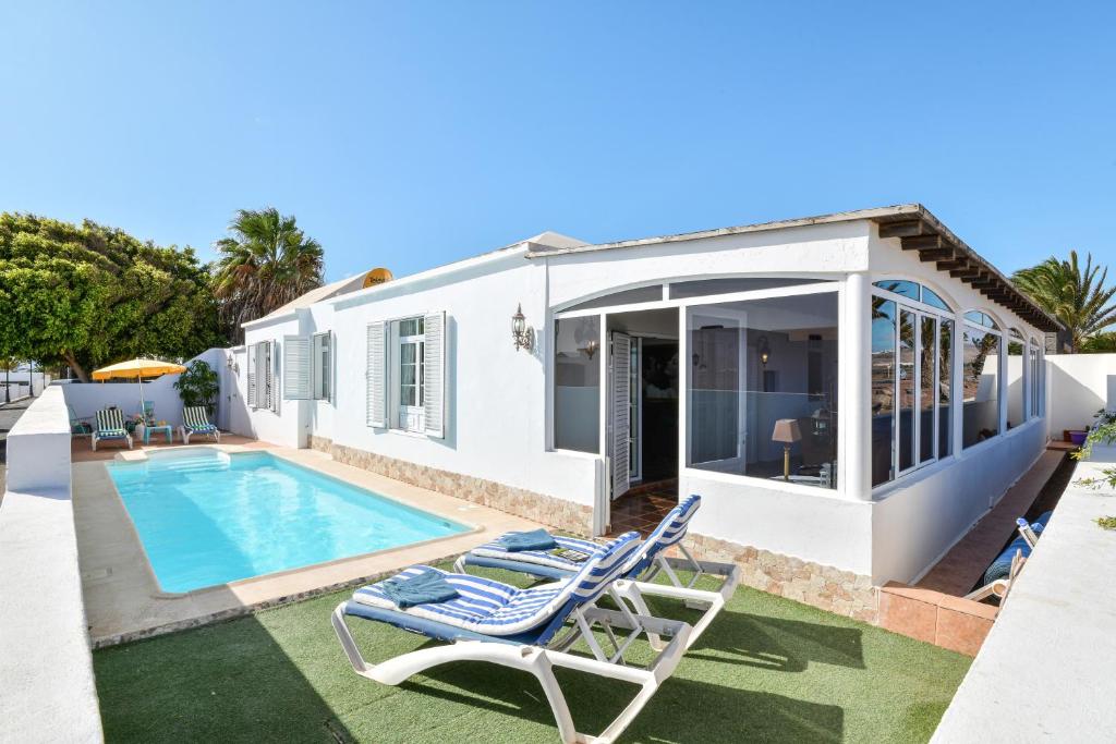 a villa with a swimming pool and a house at Villa Rústica con piscina privada in Tías