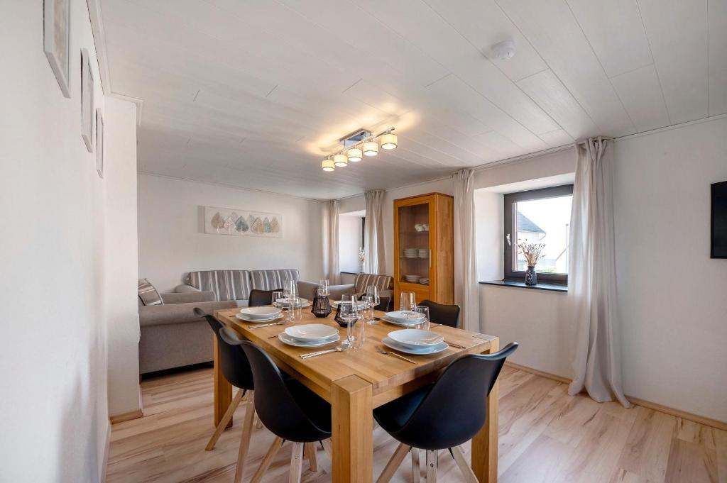 a dining room with a wooden table and chairs at Haus Seezeit in Freilingen