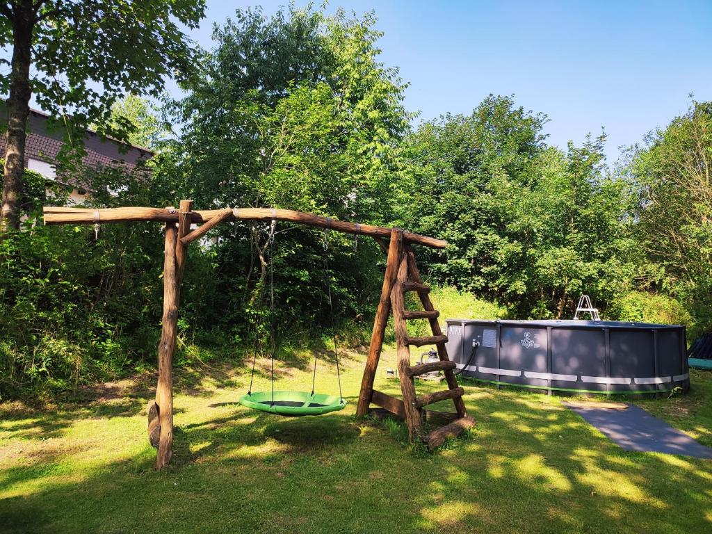 a swing set in a yard with a swing at Sauerland Alm Winterberg 5 mit Pool in Hallenberg