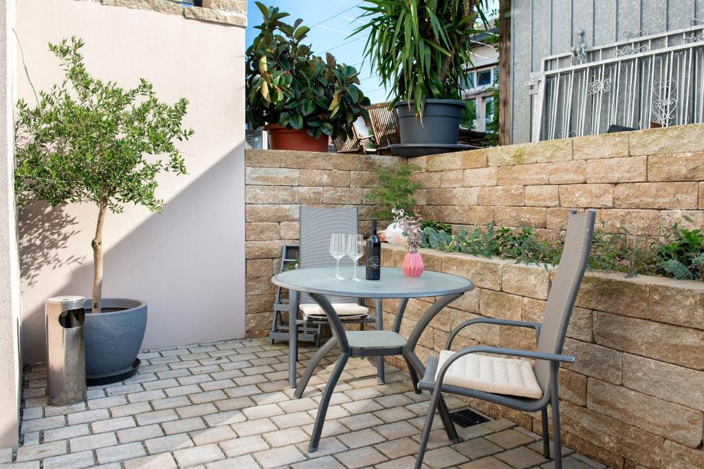 a patio with a table and chairs and a tree at Casa Ruf in Orsingen-Nenzingen