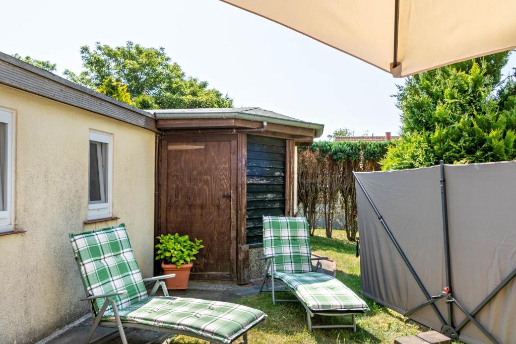 two chairs and an umbrella on a patio at Ferienwohnung Kleiner Strandfloh in Wangerooge