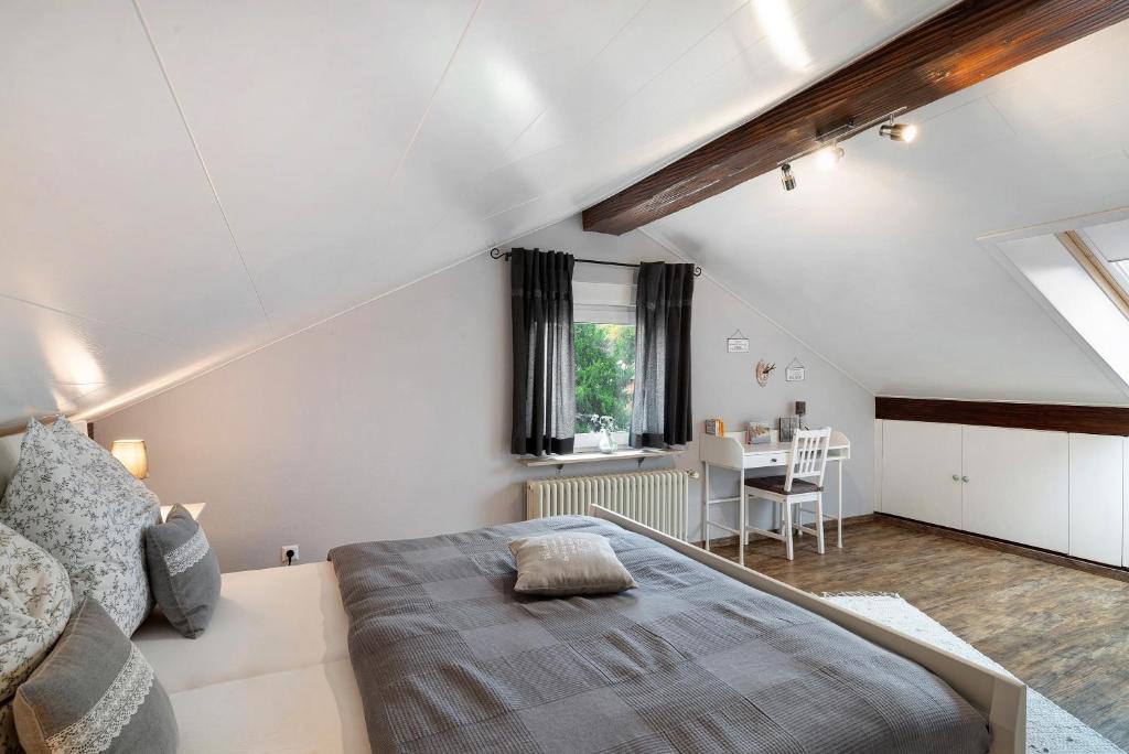 a attic bedroom with a bed and a table at Schwarzwaldtani - Dörfle in Weier
