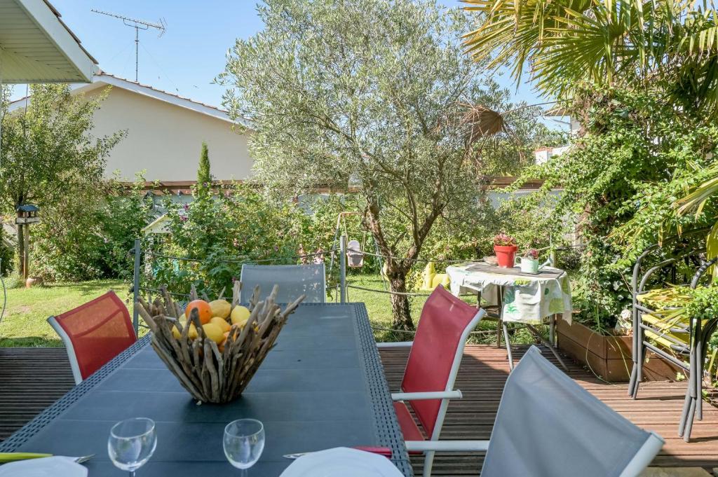 a table with a bowl of fruit on top of it at Maison agréable et tranquille in Gujan-Mestras