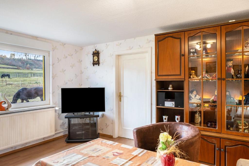 a living room with a television and a table at Haus am Candelaber in Altenbergen