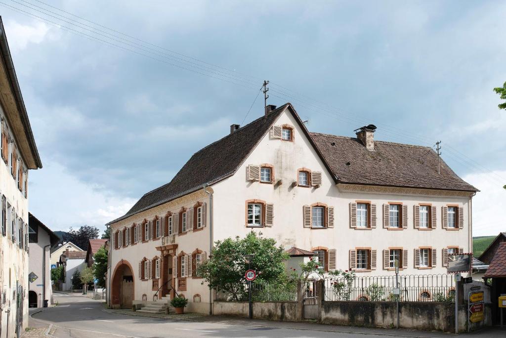 a large white building with a black roof at Ferienwohnung im Gehöft in Müllheim