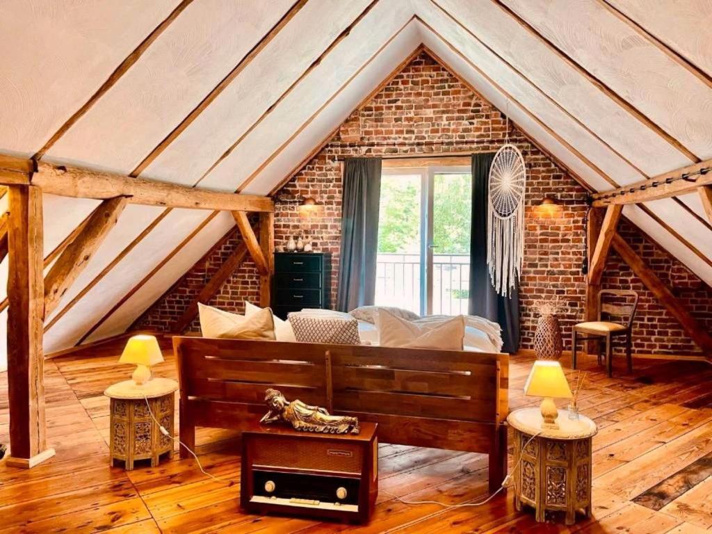 a living room with a couch and a brick wall at Ferienhaus am Rande des Spreewald in Heinersbrück