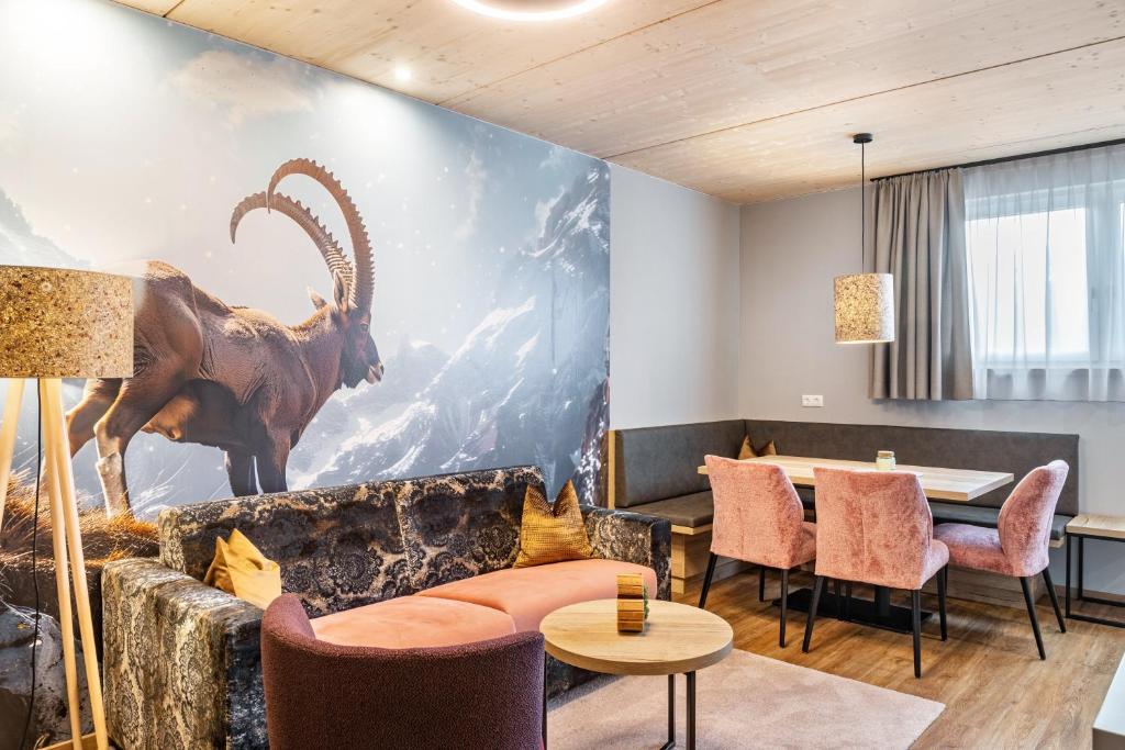 a living room with a large painting of a antelope on the wall at Apartment Steinbock in Pflach