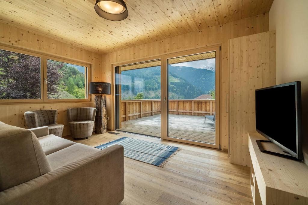 a living room with a couch and a flat screen tv at Naturapartments Alpreid Fichte in San Pancrazio dʼUltimo