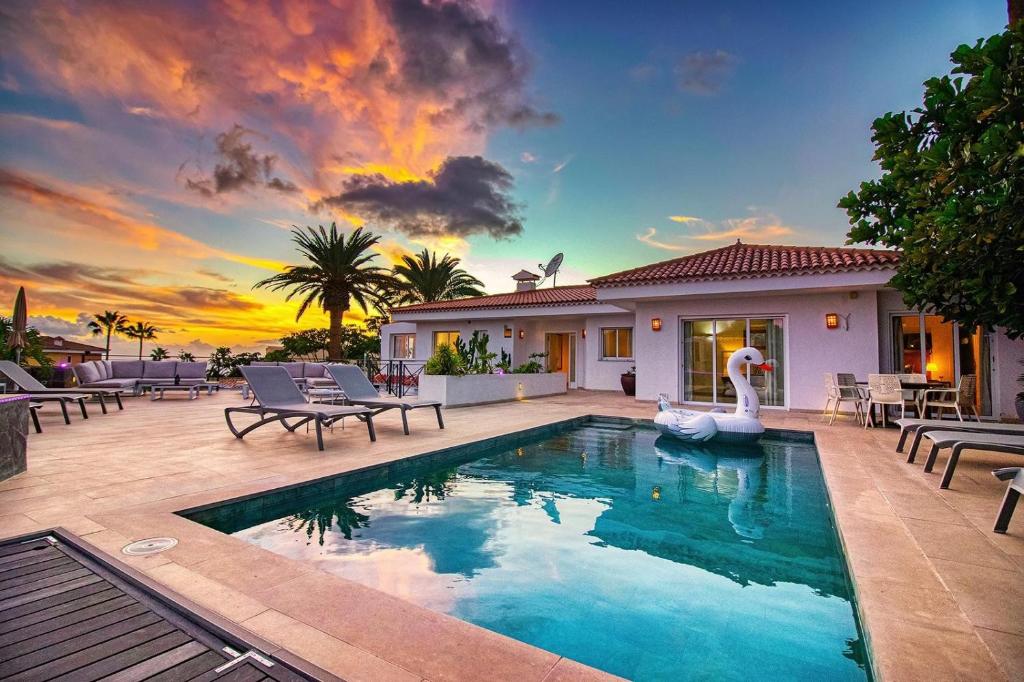 a swimming pool with a swan in front of a house at Villa Ginevra in Arona