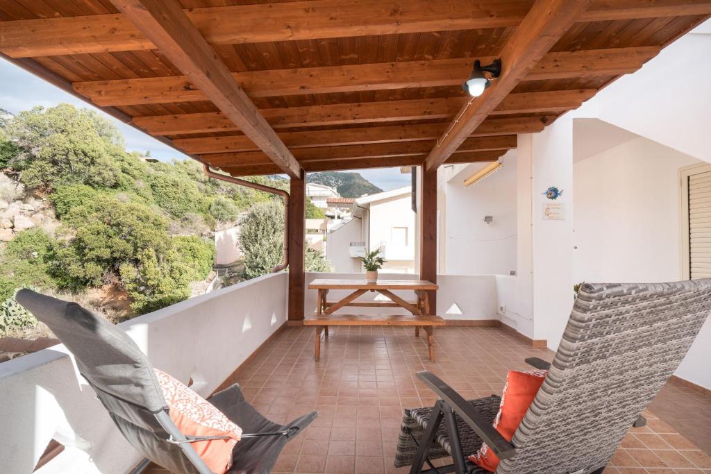 a balcony with two chairs and a table at Holiday vista Montagna in Cala Gonone