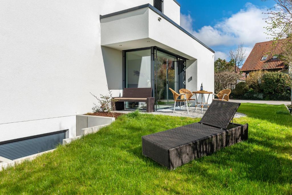 a house on a lawn with a table and chairs at Design Apartment Mettnaublick in Radolfzell am Bodensee