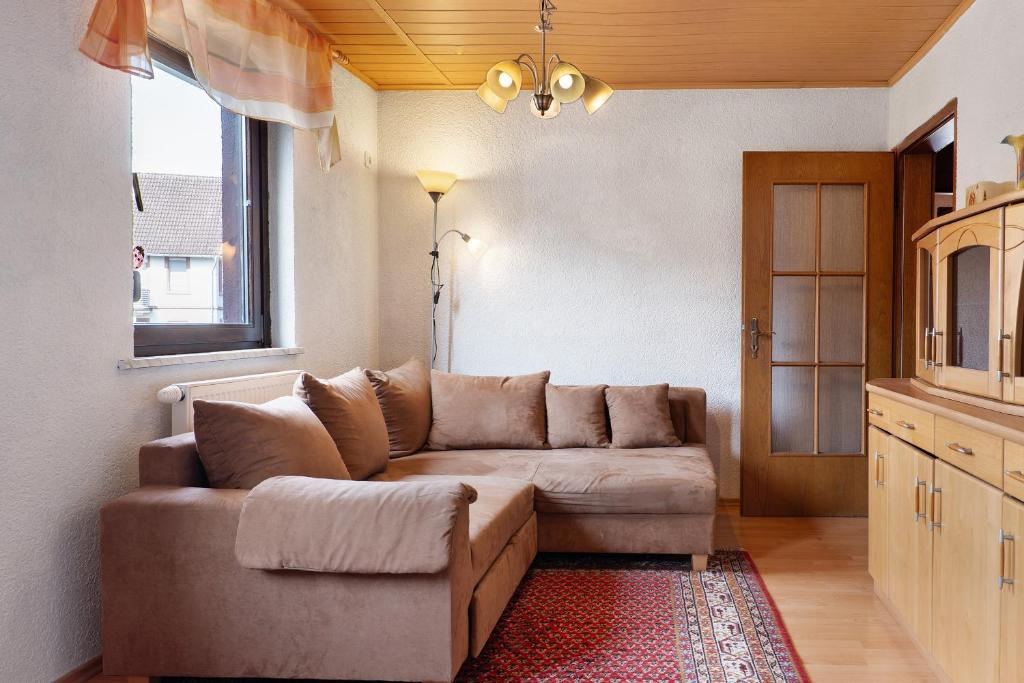 ein Wohnzimmer mit Sofa und Fenster in der Unterkunft Brown in Bad König