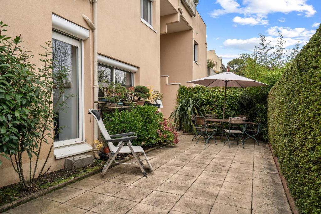 a patio with a table and an umbrella at Terrasse de Malissol in Vienne