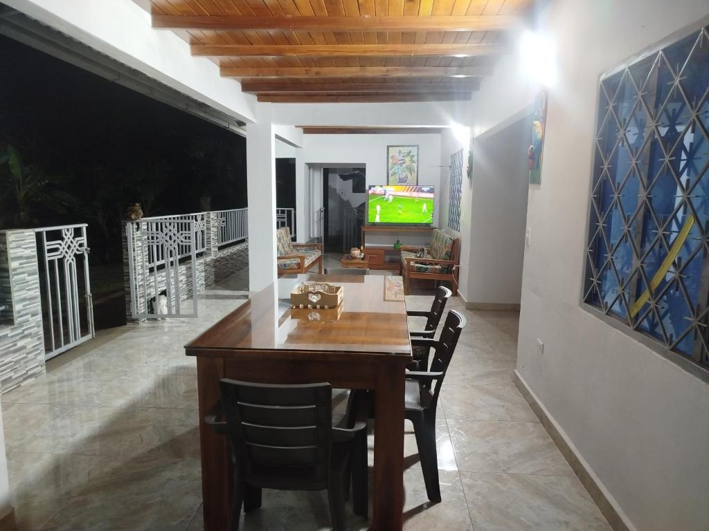 a dining room with a table and chairs and a television at Villa ceiba in Guaduas