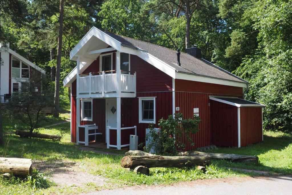 a red building with a balcony and a porch at Ferienhaus Seebär in Baabe