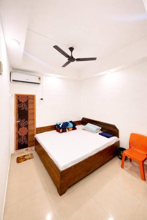 a bedroom with a bed and a ceiling fan at Mannat Lodge in Hailākāndi