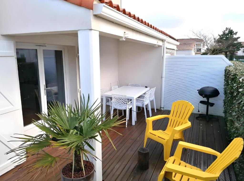 a patio with two yellow chairs and a table at Maison La Vendéenne - Ref 508 in La Tranche-sur-Mer