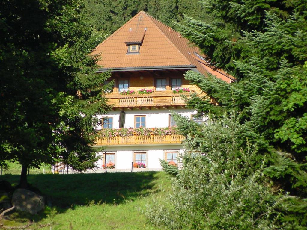 a house with a balcony with flowers on it at Klausenhof Schonach in Obertal
