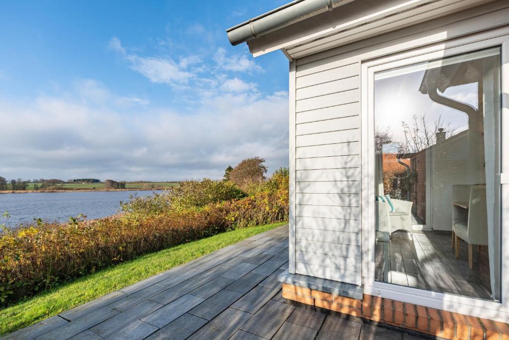 a large window on the side of a house next to the water at Sonnenuferhaus in Kosel