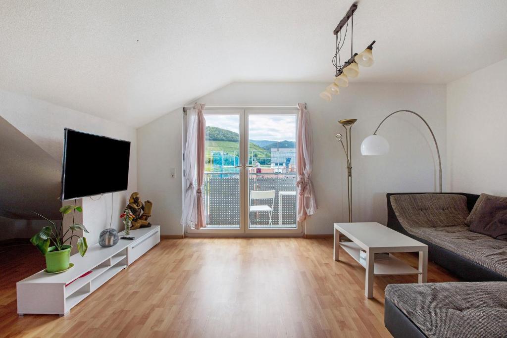 a living room with a couch and a tv at Haus Castellbergblick Dachgeschoss in Ballrechten