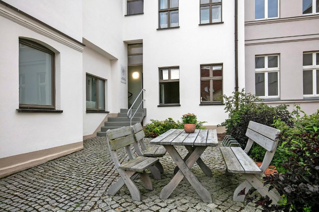 a picnic table and two chairs in front of a building at Luckau Appartements 1695 in Luckau