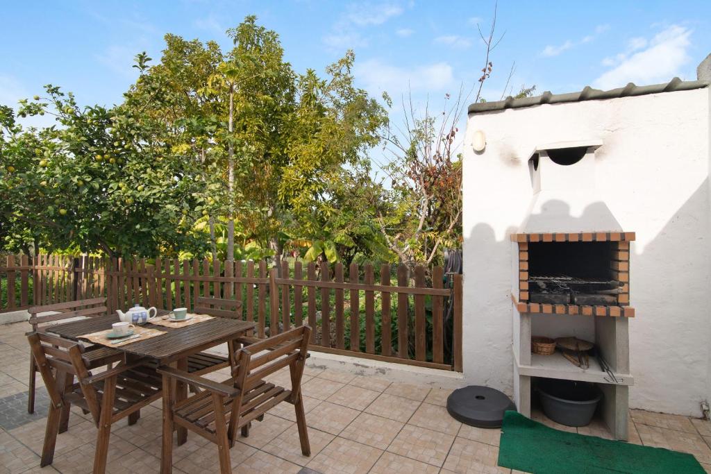 a patio with a table and a fireplace at Quinta do Mestre - Casa Do Mar in Tavira
