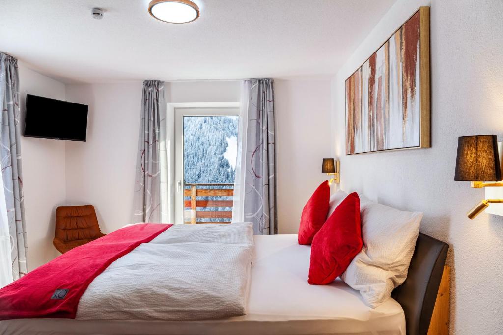 a bedroom with a bed with red pillows and a window at Apart Elena in See