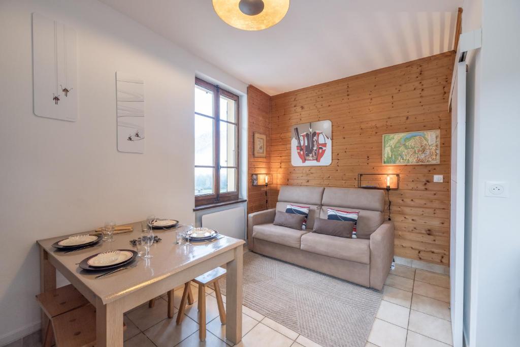 a living room with a table and a couch at Les Narcisses in Morillon