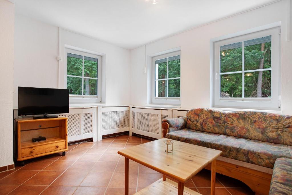 a living room with a couch and a tv at Haus Seeadler Wohnung 10 in Koserow