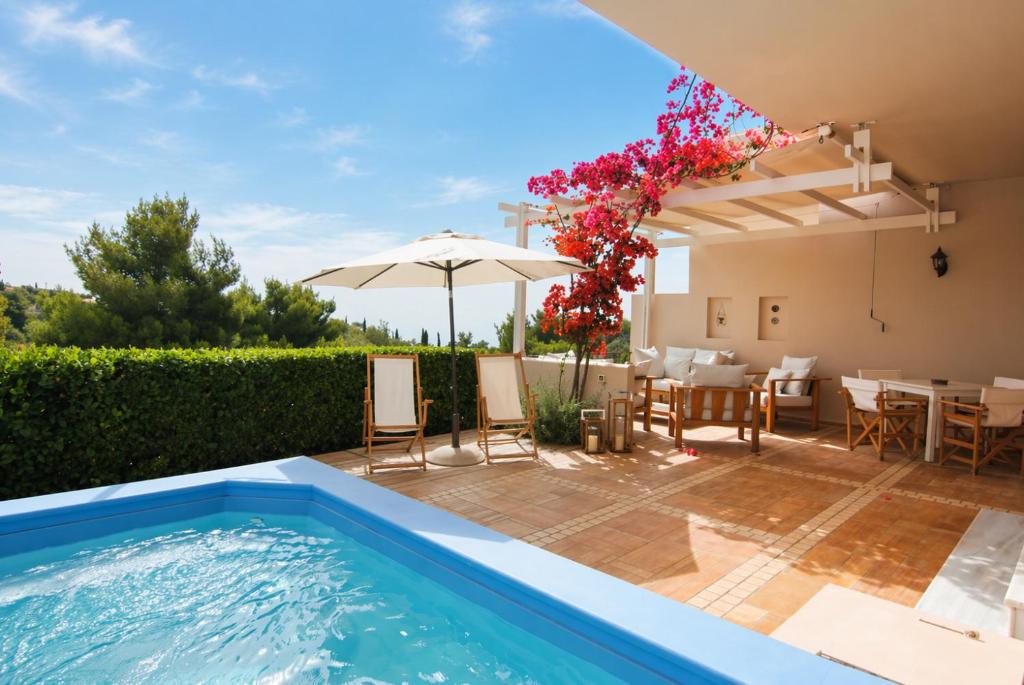 a villa with a swimming pool and a table and chairs at Pentathlon Villa Collection - Porto Cheli Private Pool Getaways in Porto Heli