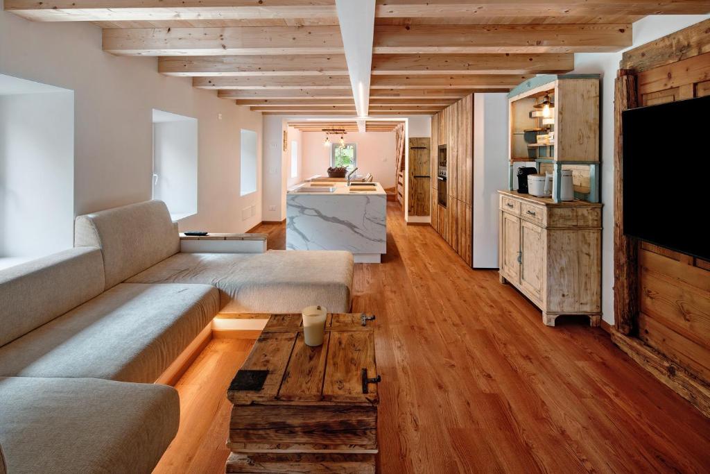 a living room with a couch and a table at Thari House Dolomiti in Piaia