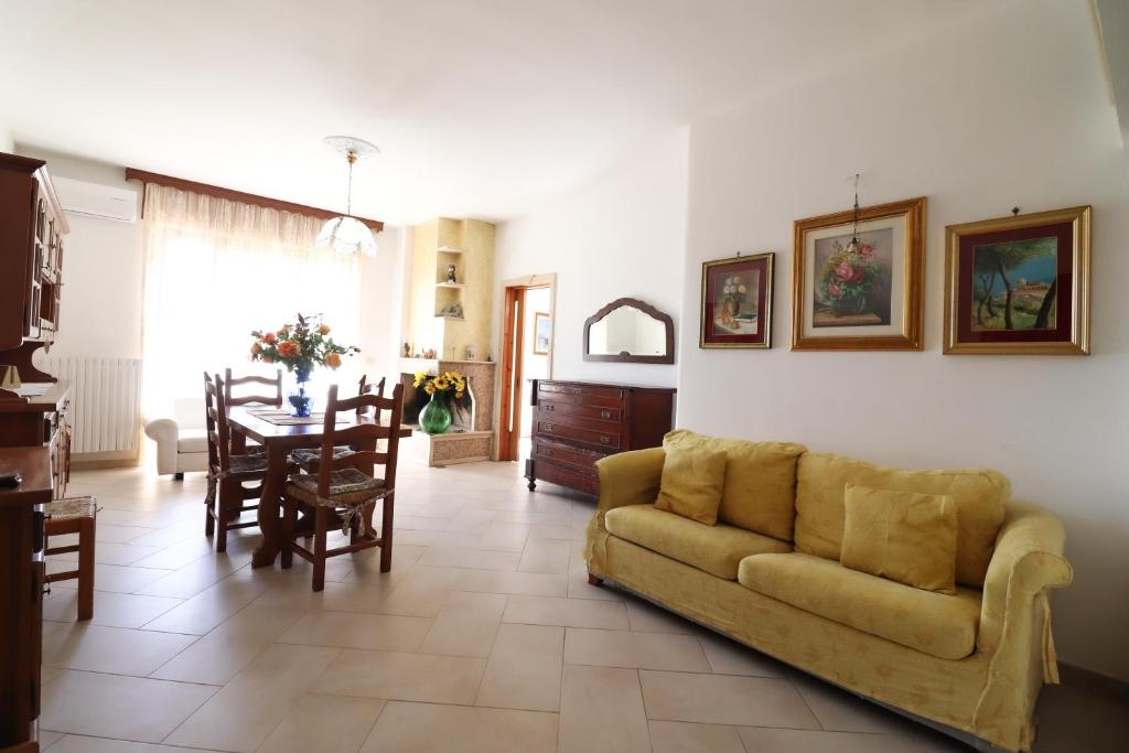 a living room with a yellow couch and a table at Casa Kefera a Otranto in Otranto